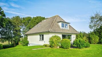 A single-story house with a sloped roof, a small porch, and a well-maintained lawn.