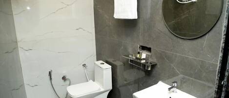 A modern bathroom with a toilet, sink, and shower.