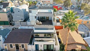 Un immeuble résidentiel moderne à plusieurs étages, doté d’un toit plat, de grandes fenêtres et d’un balcon bien visible.