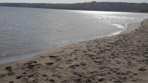 Ein Sandstrand mit Fußspuren, die zum Wasser führen.
