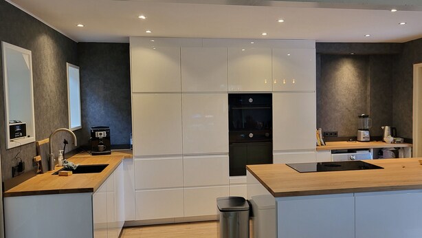 A modern kitchen with white cabinets, a wooden countertop, and a built-in oven. - Lovely family home in Laren (Laren)