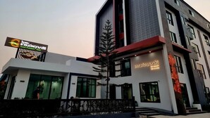 A modern hotel with a prominent sign, large windows, and a well-maintained exterior.