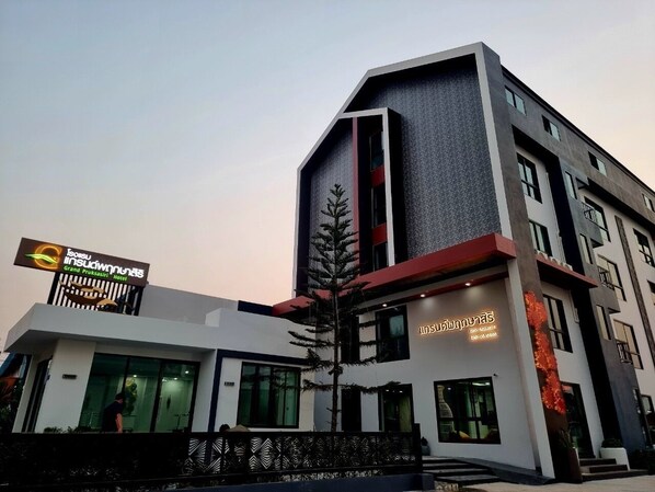 A modern hotel with a prominent sign, large windows, and a well-maintained exterior. - Grand Pruksasiri Hotel Chaiyaphum (Chaiyaphum)
