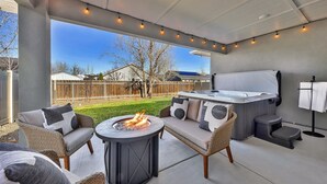 An outdoor patio with a fire pit, seating, and a hot tub. - Single Level, Luxury 4BR, Hot Tub, Game Room, Exercise Area, Near Discovery Park (Meridian)