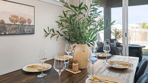 A dining table set with plates, cutlery, and wine glasses, surrounded by a potted plant and a vase. - Single Level, Luxury 4BR, Hot Tub, Game Room, Exercise Area, Near Discovery Park (Meridian)