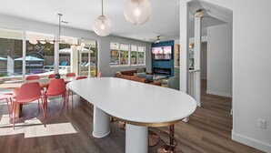 Een moderne keuken met een groot eiland, rode stoelen en hanglampen.