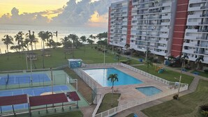 A resort with a swimming pool, tennis courts, and a view of the ocean at sunset. - Only by boat chic 2-bedroom apartment with AC, WiFi in private island in Fajardo (Fajardo)