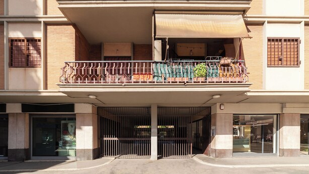 A multi-story building with a gated entrance, balconies with metal railings, and a covered outdoor seating area. - JOIVY Flat with access to central Rome (Rome)