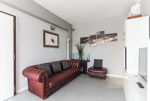 Panorama-penthouselejlighed | Opholdsområde | 40-tommers fladskærms-tv med digitale kanaler, smart-tv, bøger