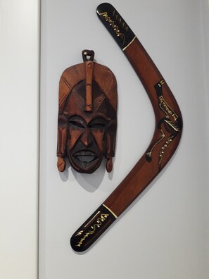 A wooden object with a carved face and a curved handle, possibly a decorative item or tool. - Attico con vista Ciampino Roma  (Ciampino)
