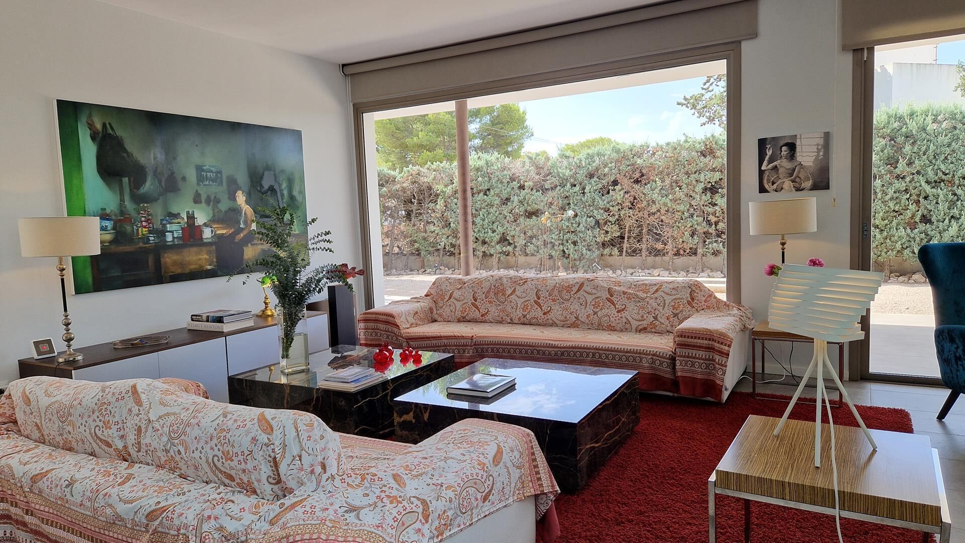 A living room with a sofa, coffee table, and a painting on the wall.
