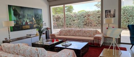 A living room with a sofa, coffee table, and a painting on the wall.