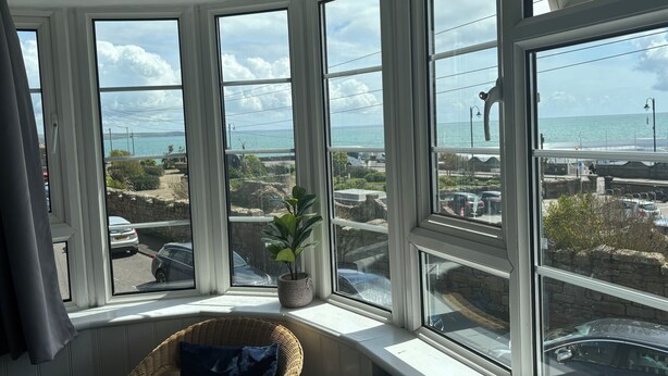 A bay window with a view of the sea and a parking area. - The Yacht Inn (Penzance)