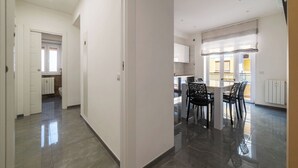 Un grand espace de vie comprenant un coin repas avec une table et des chaises, une cuisine équipée de placards et une salle de bain avec des toilettes et une douche.