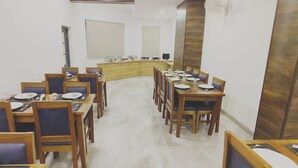 Una sala de conferencias con una larga mesa, sillas, un mostrador de madera y una pantalla para proyector.