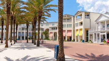 A hotel courtyard with palm trees, a covered walkway, and a building with a sign 'BROTHERS'.