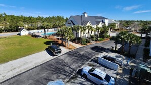 A residential area with a large house, a swimming pool, and a well-maintained lawn.