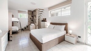 Un dormitorio con cama, mesita de noche y un banco empotrado con espacio de almacenamiento.