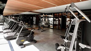 A modern gym with multiple treadmills, weight machines, and a mirrored wall. - Itaim Retreat Luxury 1 Bedroom in Itaim (São Paulo)