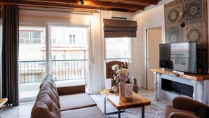 Una sala de estar con un sofá, una mesa de centro, un televisor y una chimenea.