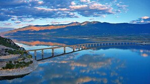 A long bridge over a calm lake with mountains in the background. - Kozani Central Nest - Homely Vibes (Kozani)