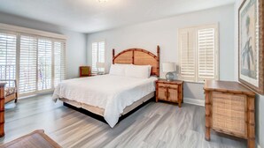 A bedroom with a large bed, wooden headboard, bedside tables, a nightstand, and a framed picture on the wall. - 3602 Fantastic 4BD Townhouse For Family Vacation (Davenport)