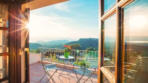 An open balcony with a view of mountains, a table, and chairs. - Villa Oneirama - Nafplio Garden Retreat (Nafplio)