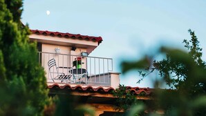A balcony with a chair, a potted plant, and a small table. - Villa Oneirama - Nafplio Garden Retreat (Nafplio)