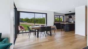 A modern kitchen with a dining area, large windows, and a view of the outdoors. - Modern house for 8 at 400m from the beach (Plouguerneau)