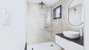 A modern bathroom with a glass-enclosed shower, a white sink, and a large mirror. - Modern house for 8 at 400m from the beach (Plouguerneau)