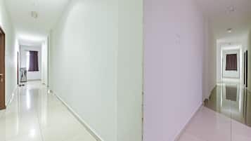 A long, narrow hallway with white walls and a tiled floor.