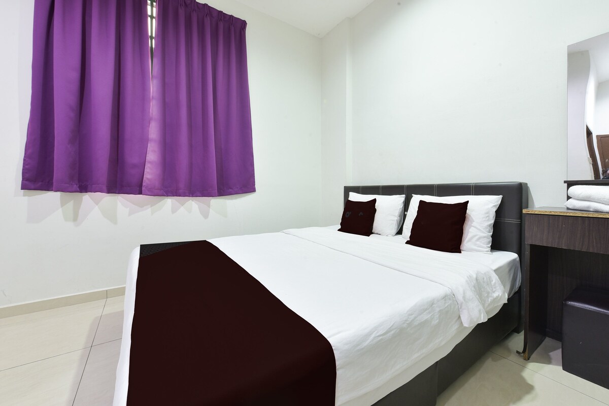 A hotel room with a bed, a desk, and a chair.