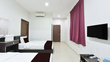A hotel room with two beds, a TV, a desk with a phone, and a mirror.