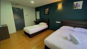 Two single beds with dark headboards, a bedside table, and a painting adorn this stylish room.