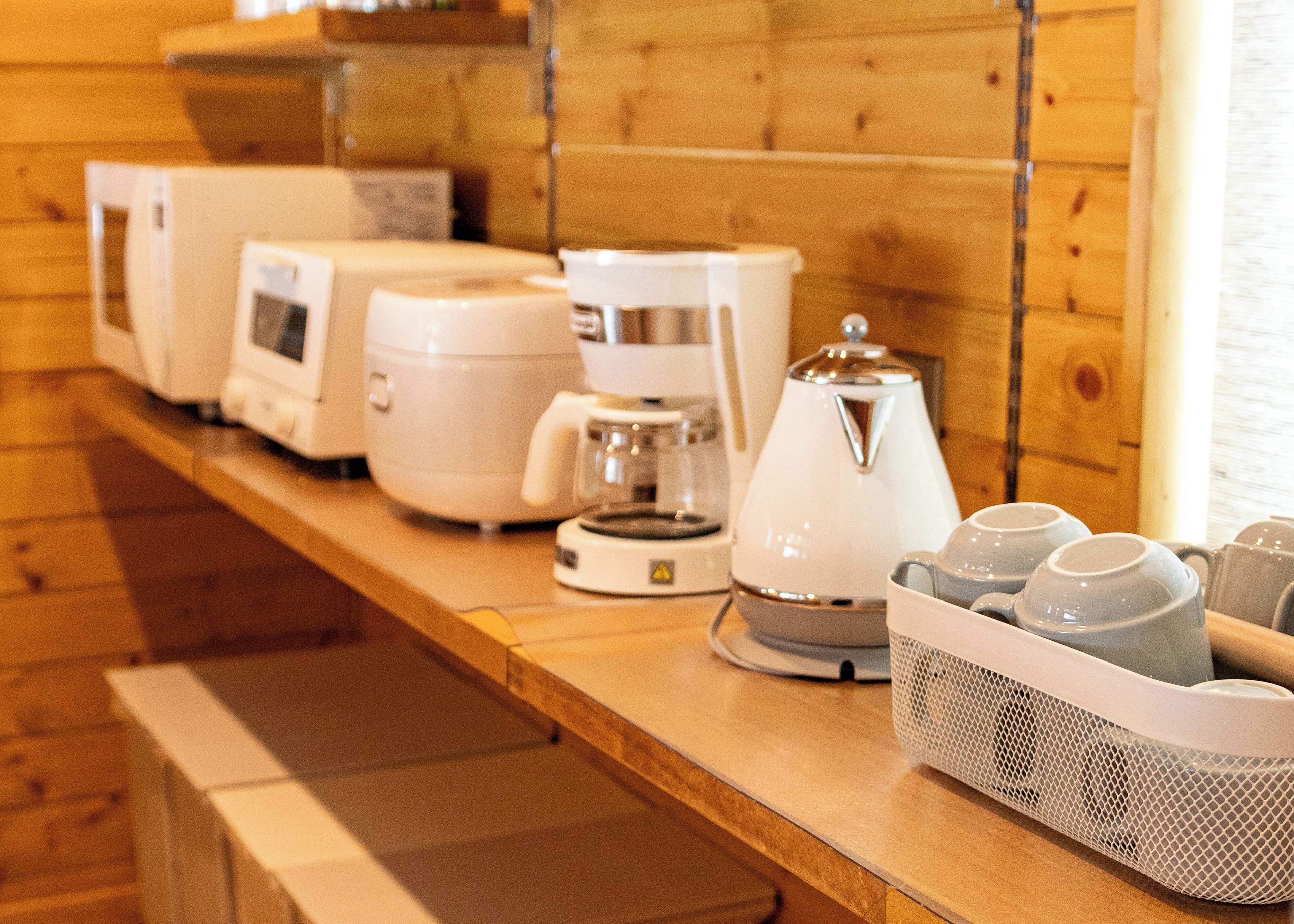 A kitchen counter with various appliances including a coffee maker, a kettle, and a food processor.