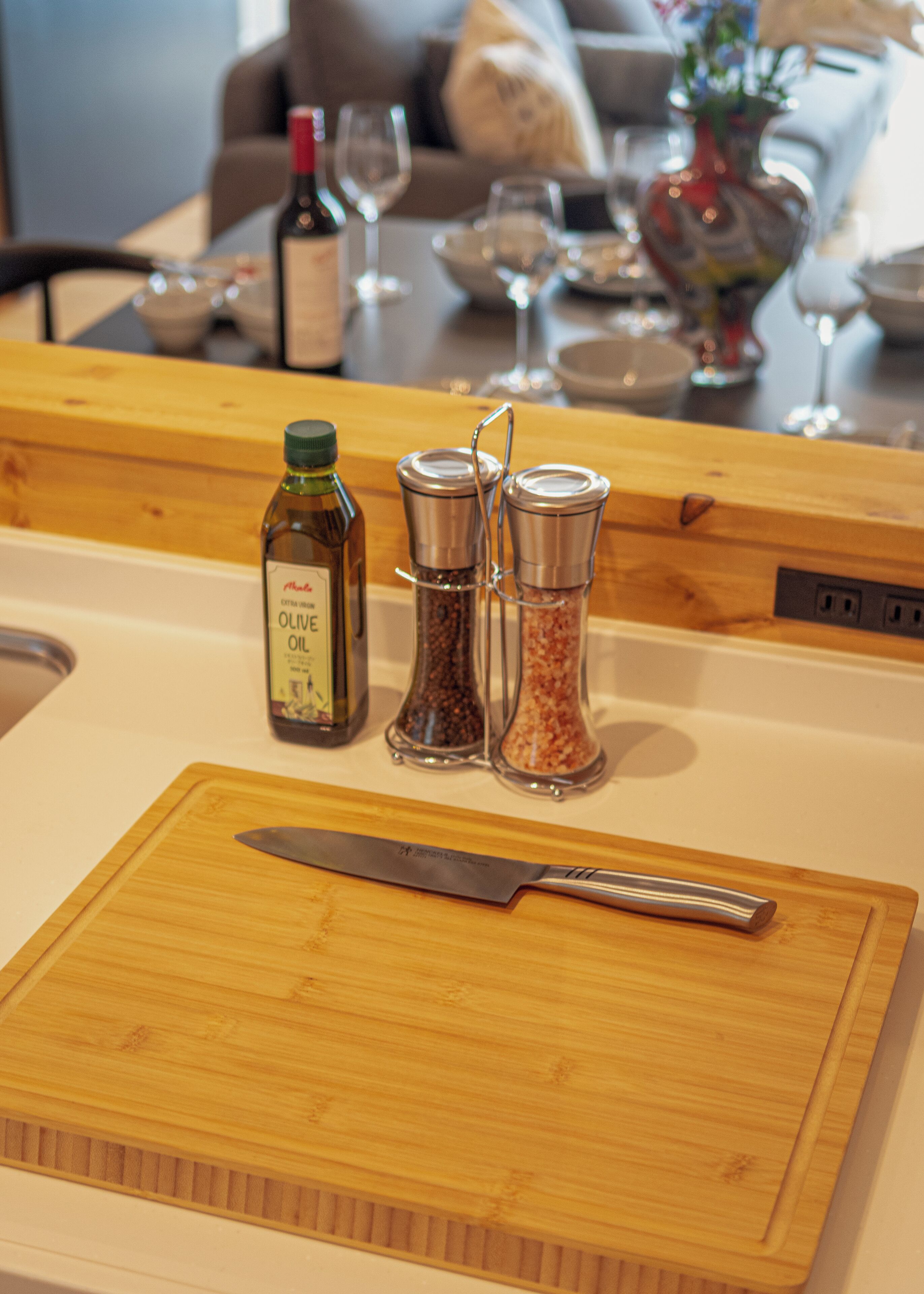 A kitchen counter with a cutting board, a knife, and two salt shakers.