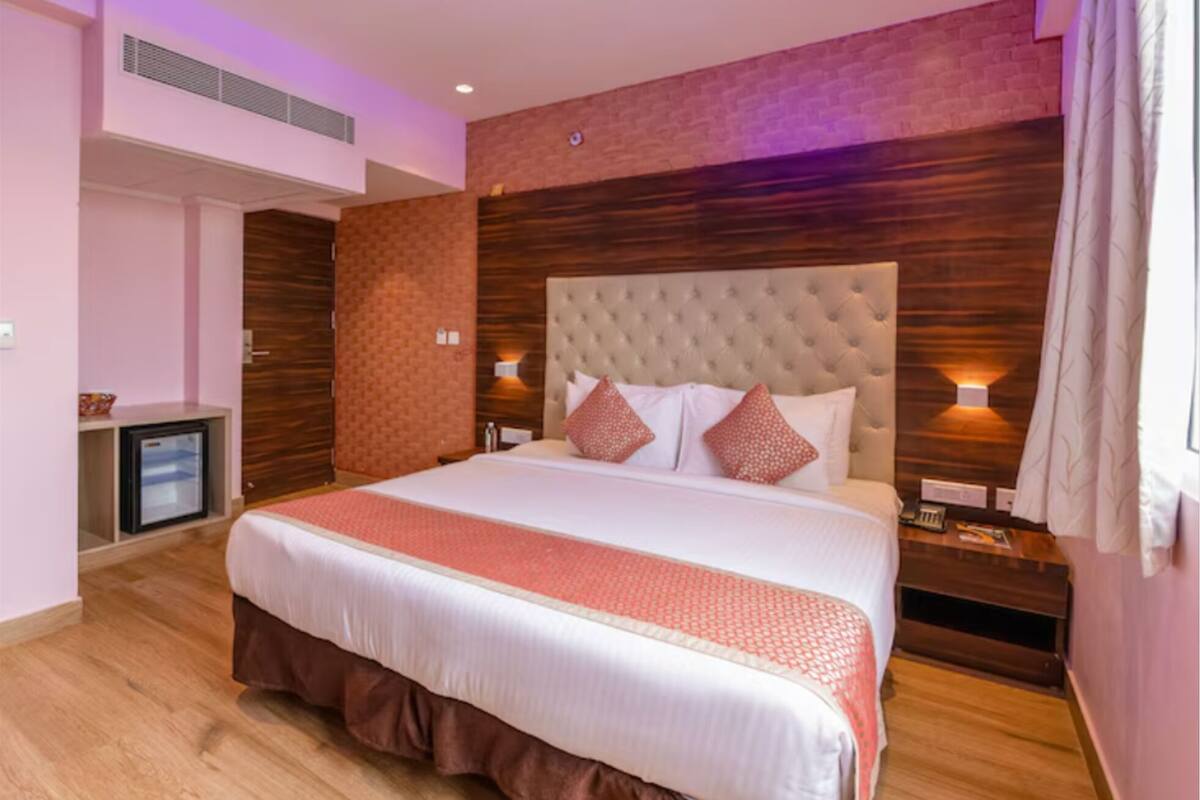 Ein Hotelzimmer mit einem großen Bett, einem kleinen Schreibtisch und einer Wand mit Backsteinmuster.
