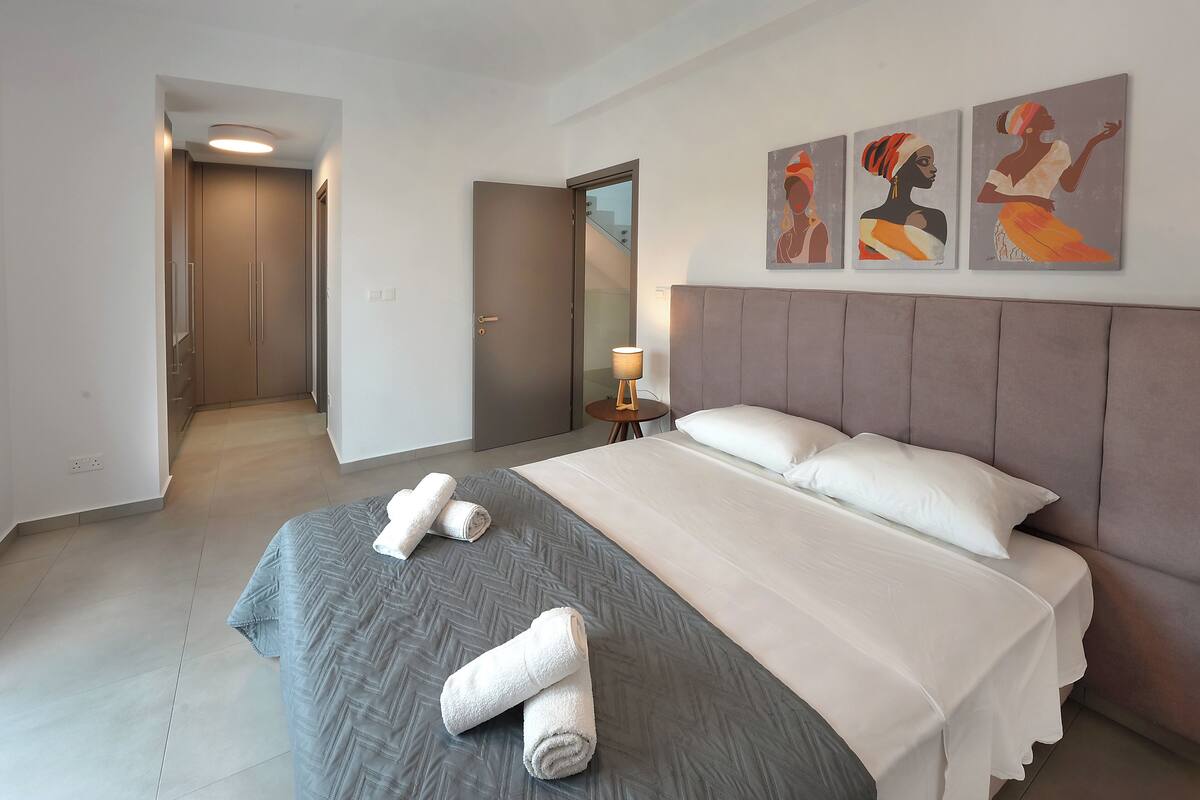 A hotel room with a bed, a nightstand, and a painting on the wall.