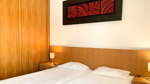 A double bed with white linens, two bedside tables with lamps, and a wooden headboard. - Marina View 1 Bedroom Apartment w Swimming Pool (Albufeira)