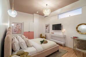 A bedroom with a bed, bedside tables, a TV, a mirror, and a window. - Stunning 2BR With Balcony on Piata Universitatii (Bucharest)