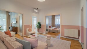 A spacious living area with a sofa set, a coffee table, and a potted plant. - Vibrant & Spacious 3BR Condos on Amzei Square (Bucharest)