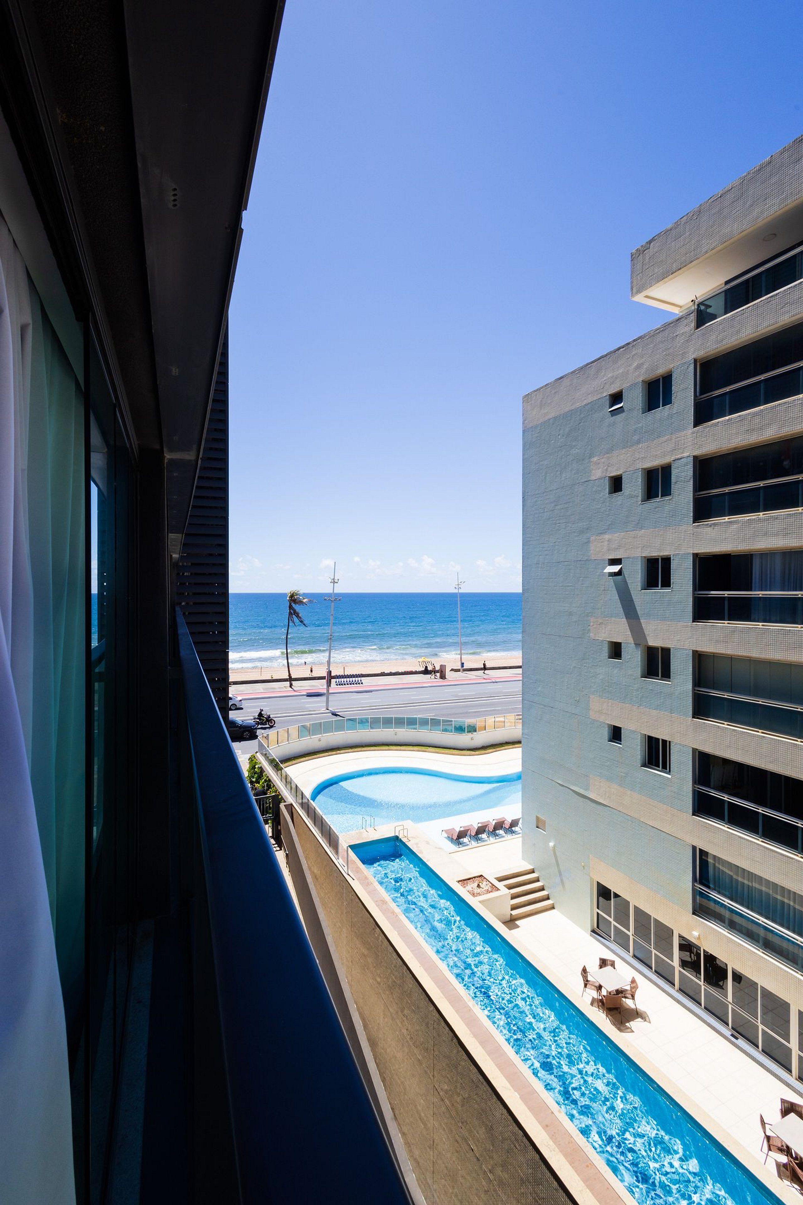 A modern building with a swimming pool and a view of the beach.