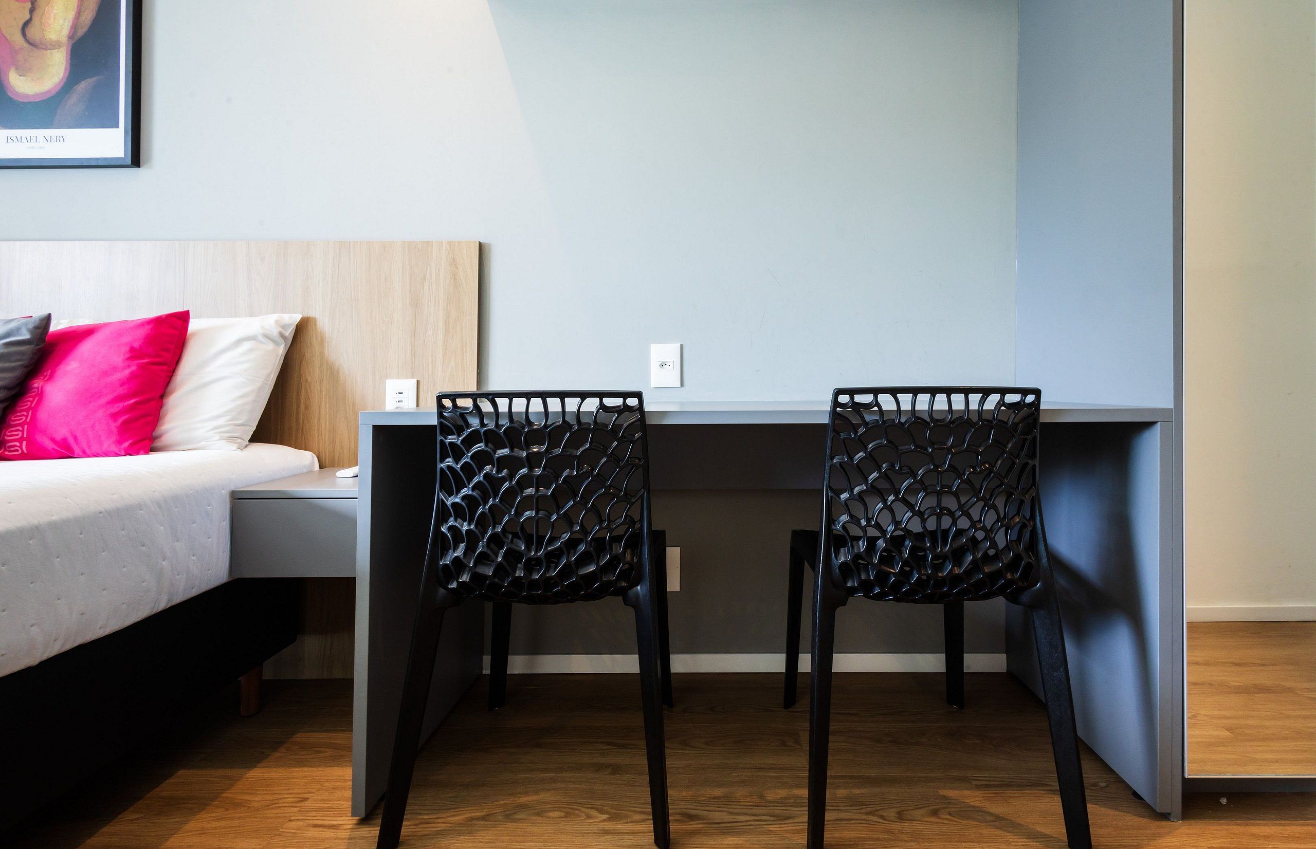 Ein modernes Schlafzimmer mit Bett, Schreibtisch und zwei Stühlen.