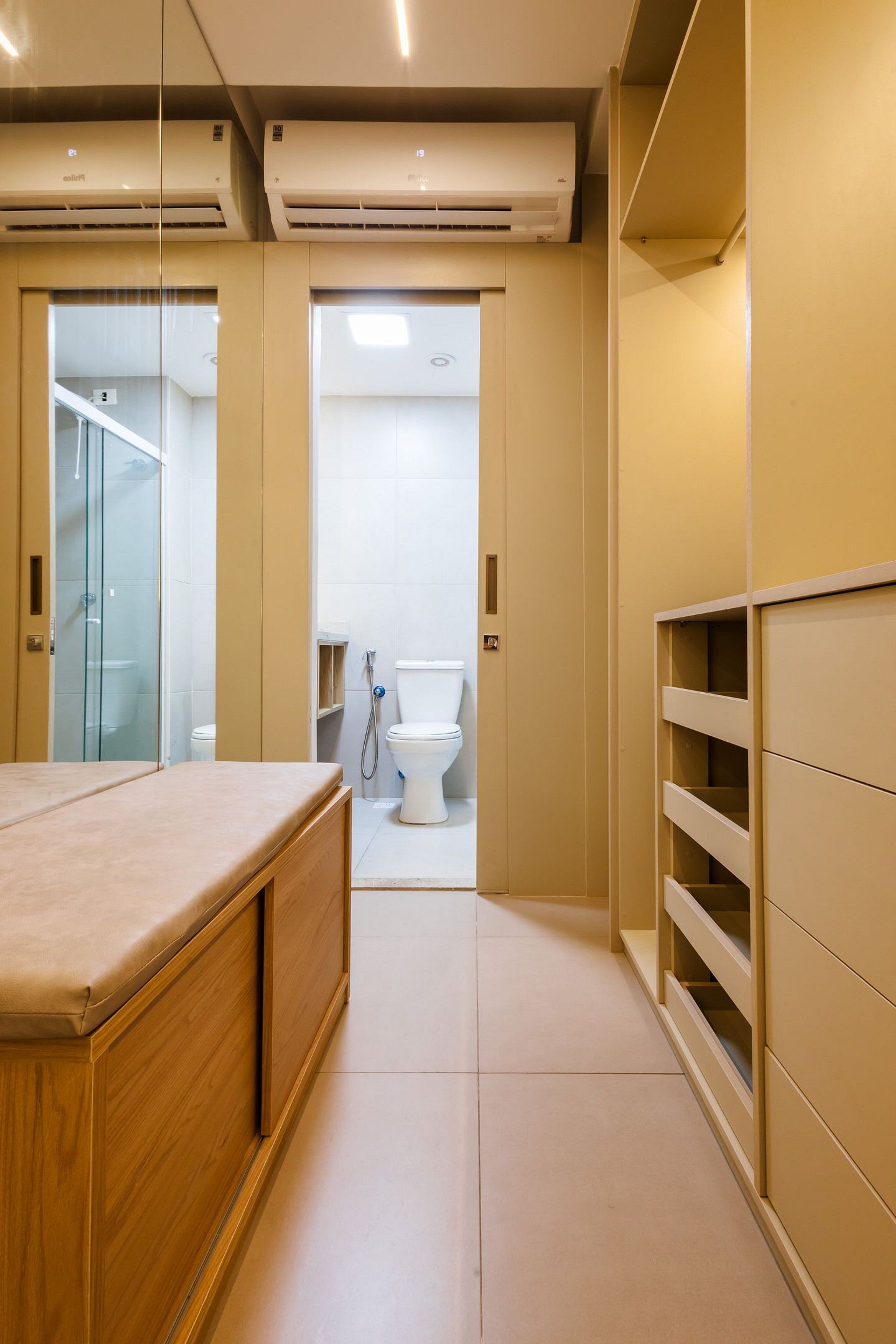 Uma casa de banho moderna com cabine de duche em vidro, sanita e toucador com espelho.