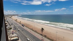 A coastal road with a beach and ocean on the right. - Art Studio Housi Salvador by Carpediem (Salvador)
