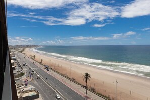 A coastal road with a beach and ocean on the right. - Art Studio Housi Salvador by Carpediem (Salvador)