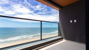 A modern room with a large window overlooking a beach and ocean. - Art Studio Housi Salvador by Carpediem (Salvador)