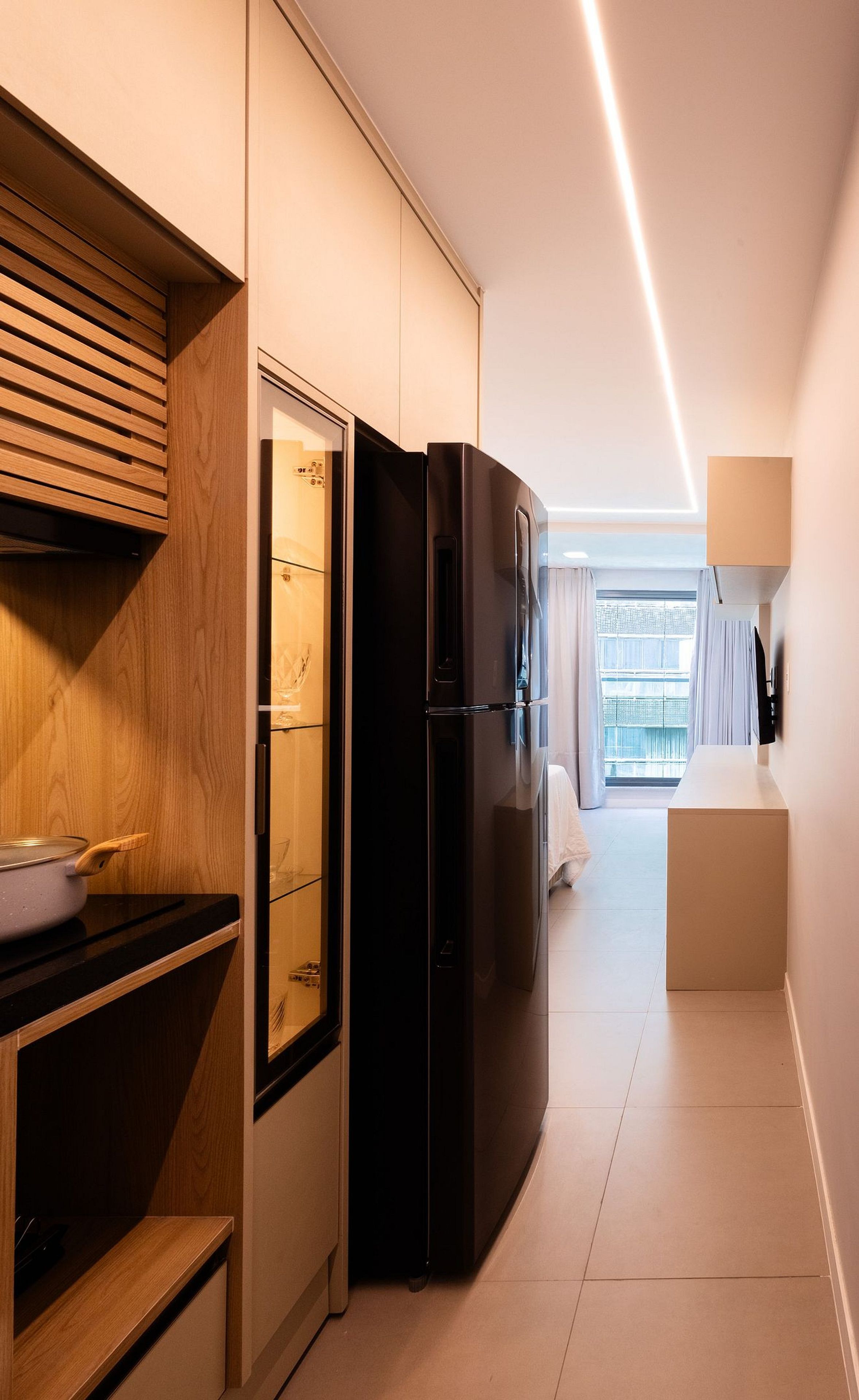 A modern kitchen with a built-in refrigerator, wooden cabinetry, and a countertop with a bowl.