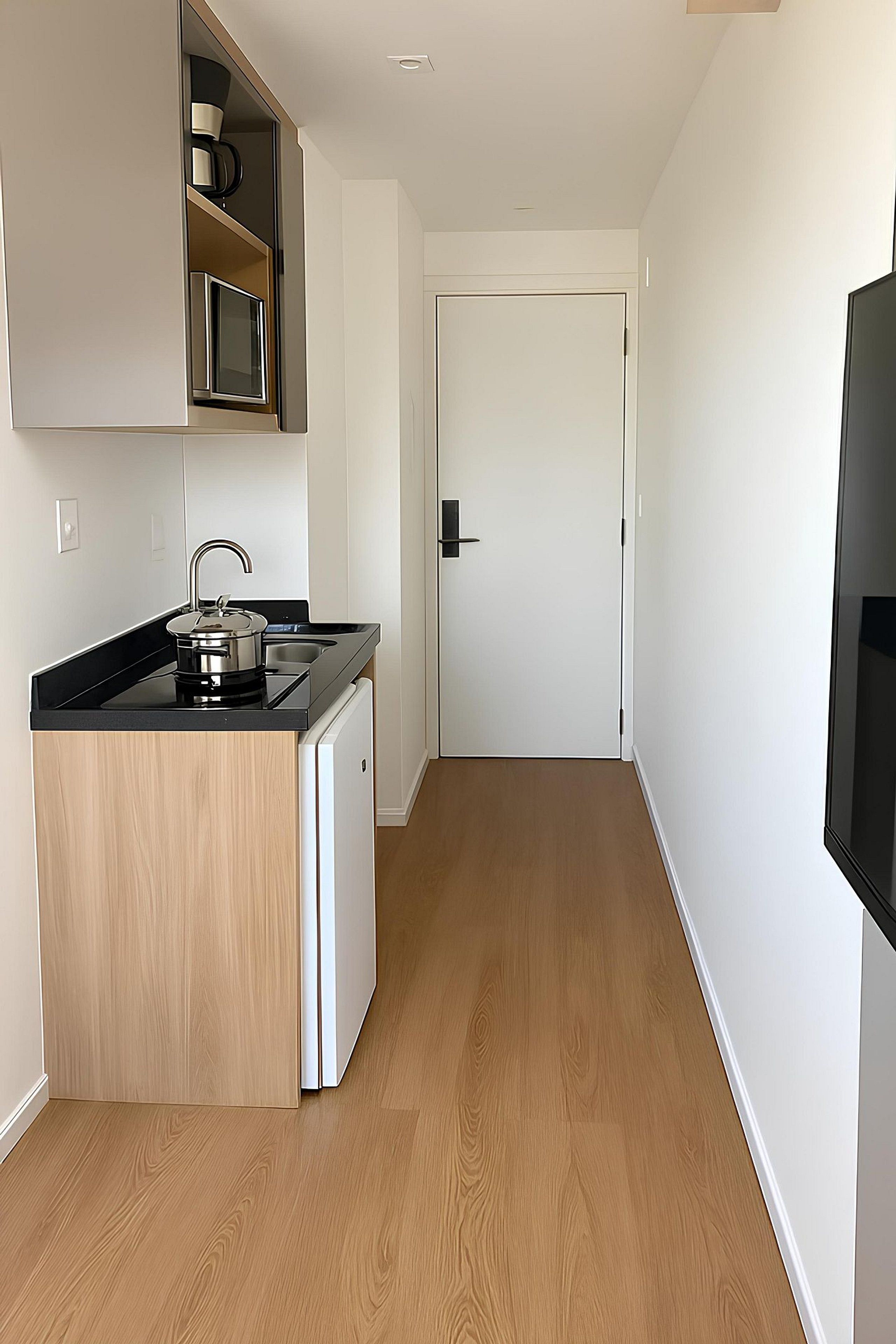A compact kitchen with a built-in stove, a sink, and a microwave.