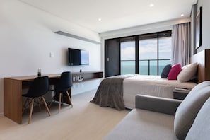 Une chambre d’hôtel moderne avec un grand lit, un bureau et une télévision.